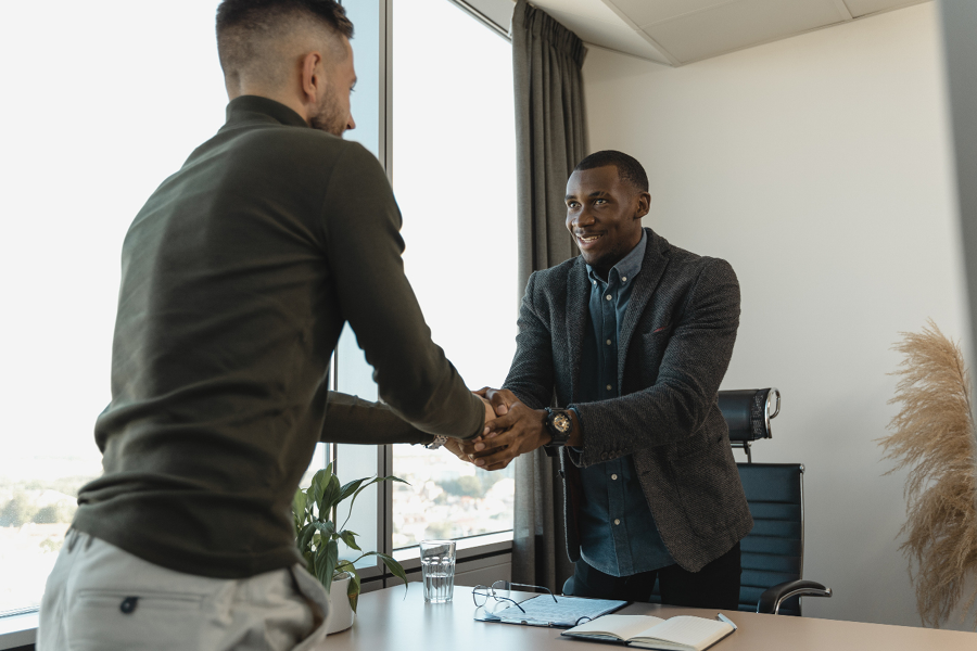 Professional development is key to career success | Two men shake hands in an interview setting