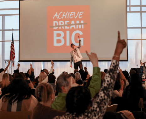 NSLS crowd holding up number one signs at a speaking event