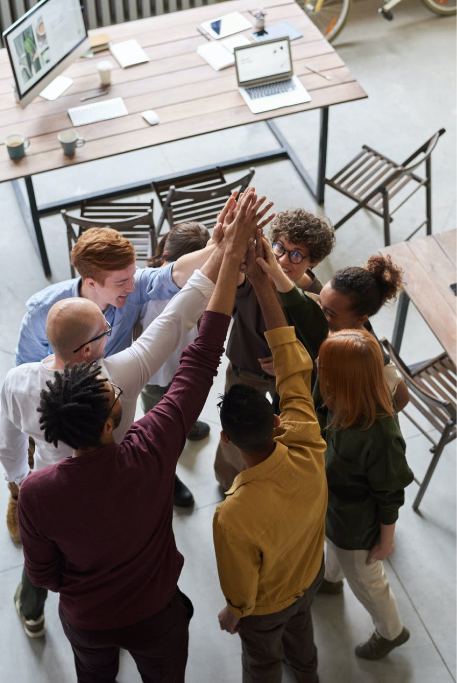 A group of people high fiving in a circle.