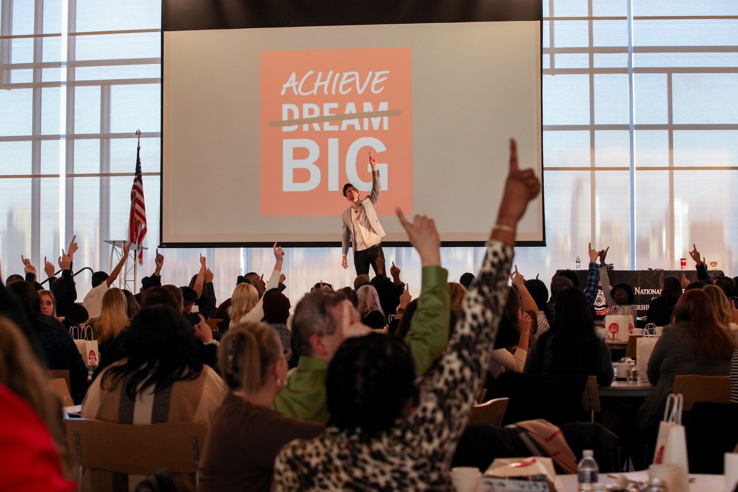 Conference Attendees Pointing Upward.